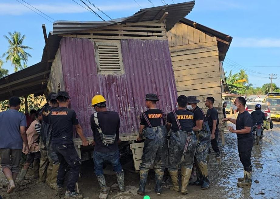 Bahu Membahu, Brimob Pindahkan Rumah Terseret Banjir yang Melintang di Jalan Nasional Tamiang–Langsa